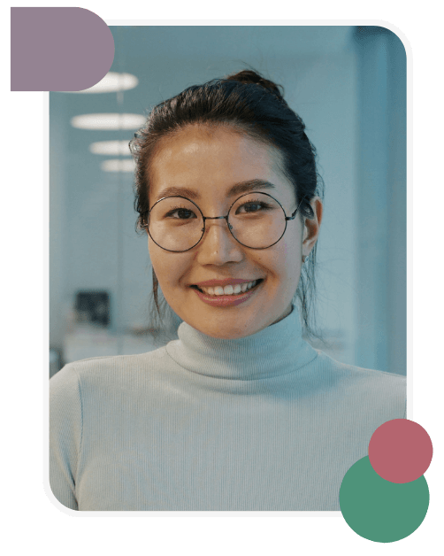 A person with glasses and a light turtleneck smiles at the camera in an office setting; geometric shapes decorate the image corners.