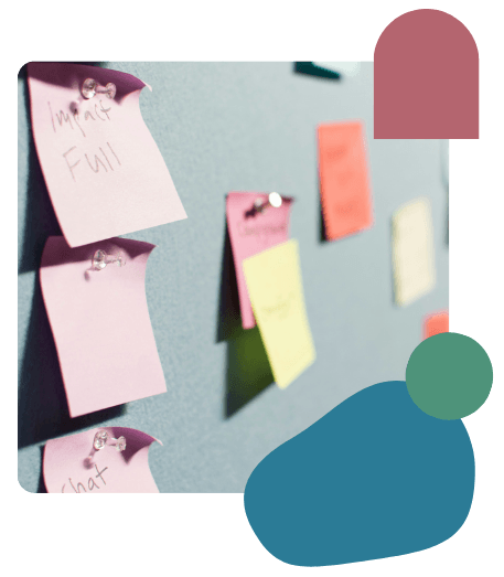 Colorful sticky notes pinned to a blue board, displaying various handwritten notes in a creative workspace setting.